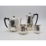 A four piece silver tea service, of faceted form, with wooden handles and faceted finials, by