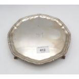A Victorian silver card tray, of octafoil form with a gadrooned rim, on four ball and claw feet,