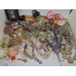 A large box full of costume jewellery to include mirror compacts, statement necklaces etc