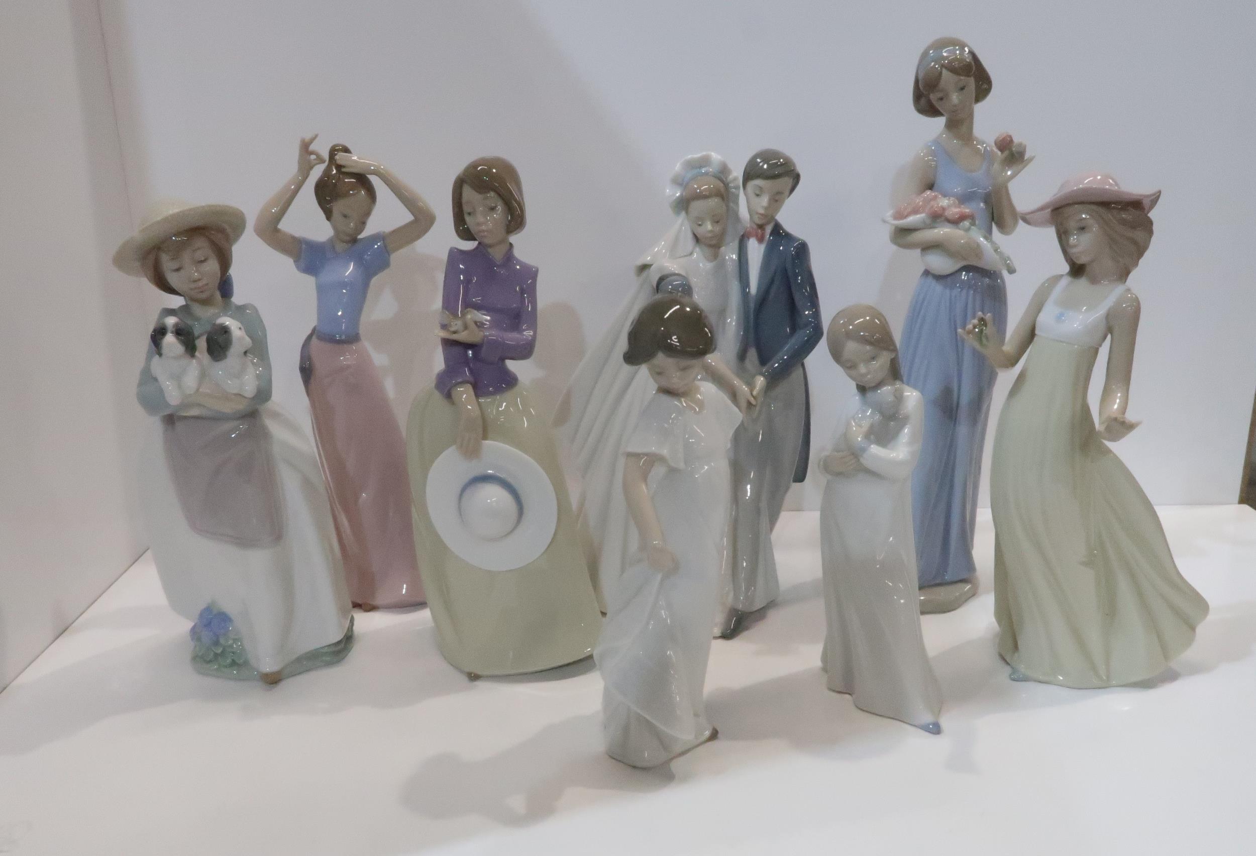 Eight Nao figures including a bride and groom, girl with puppies etc Condition Report:Available upon