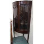 A 20th century mahogany bow front glazed corner cabinet with pair of glazed doors over single drawer