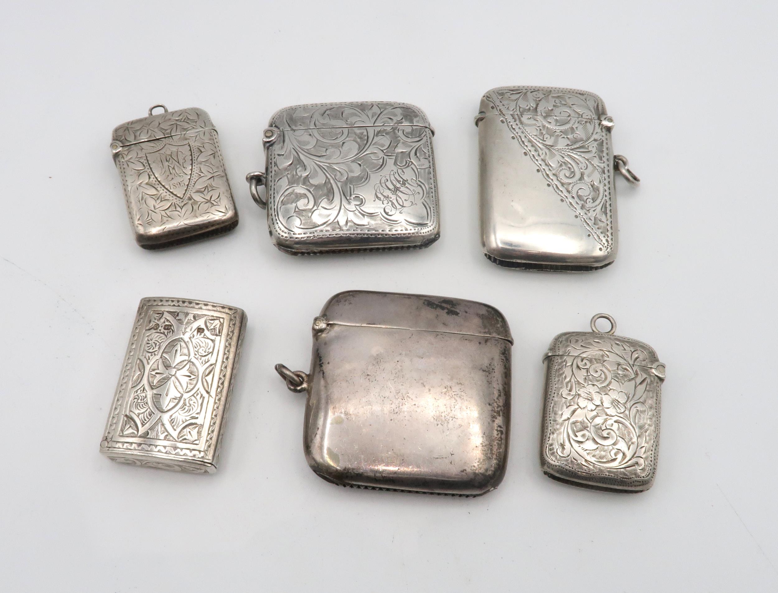 A collection of silver vestas, five with engraved scrolling foliate decoration, one by William