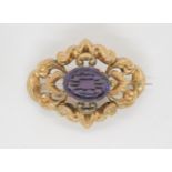 A yellow metal Victorian brooch set with a purple glass gem, length 5.5cm, weight 11.6gms