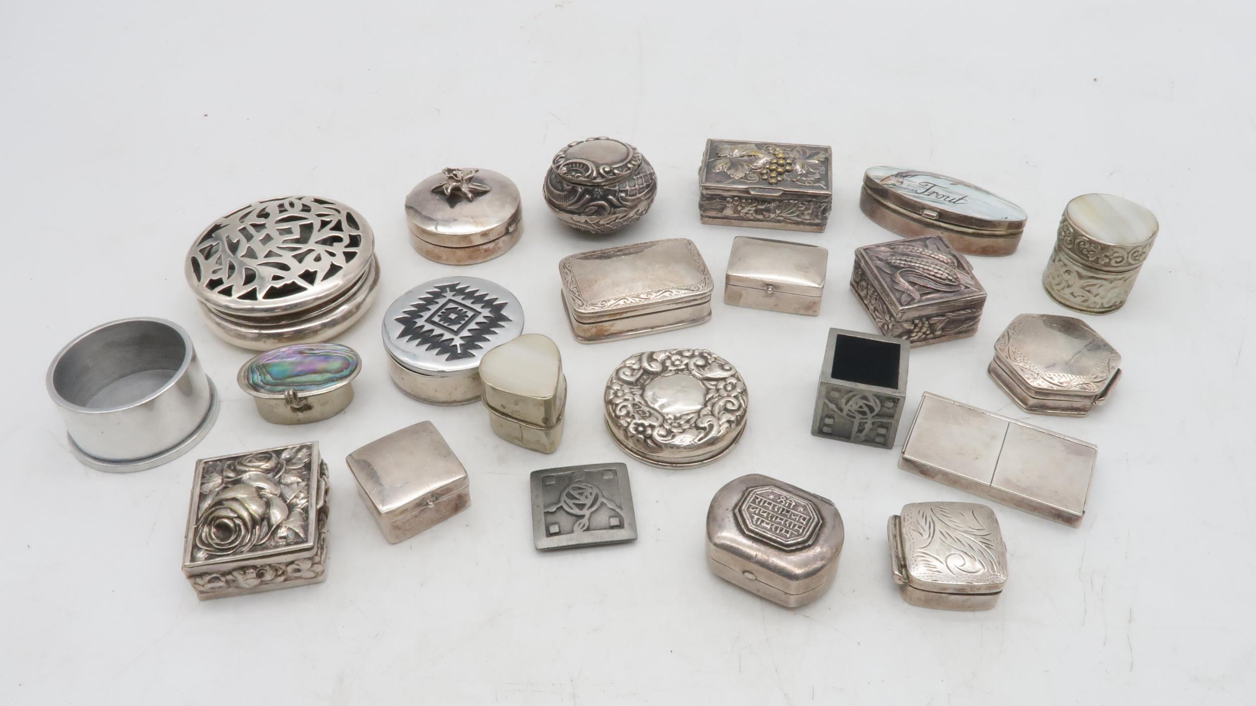 A collection of silver, white metal and EPNS pill boxes, one example with a pierced lid,