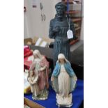A patinated figure of St Francis of Assisi together with a plaster figure of Mary and another figure