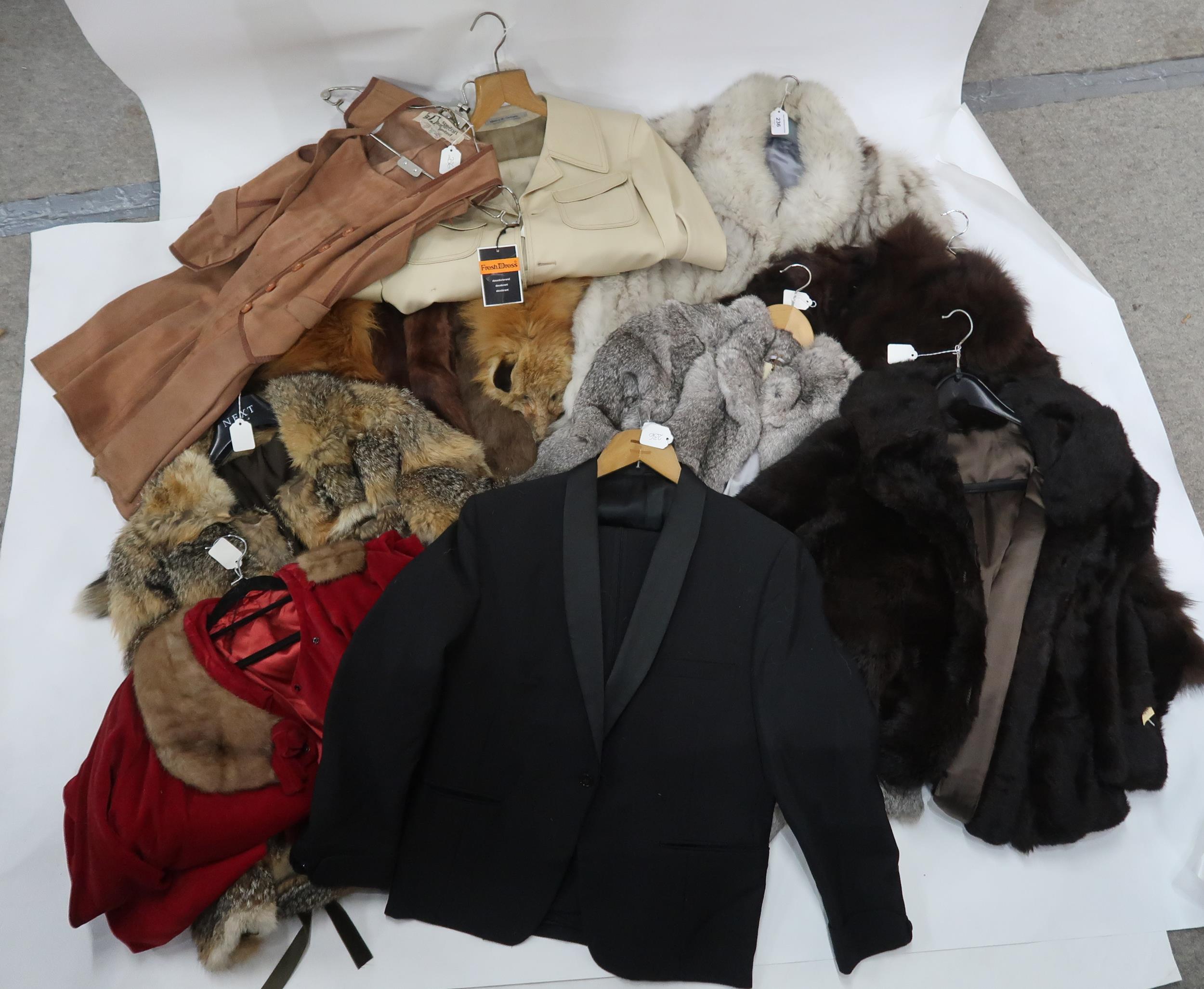 A pale grey and leather jacket with cut design, fox stole, other stoles, a brown fur cape, a long