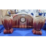 A French pottery clock garniture, in peach and red glaze Condition Report:Available upon request