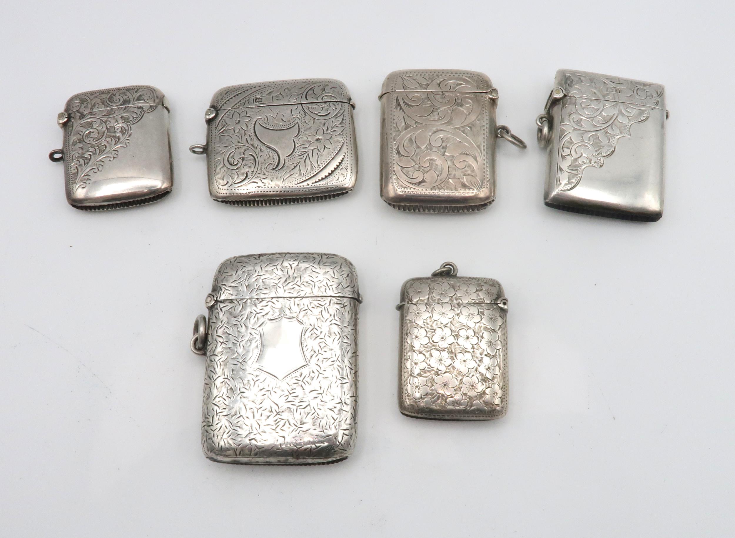 A collection of silver vestas including an example with engraved foliate decoration surrounding a