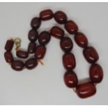 A string of cherry amber coloured beads, largest bead 2.4cm x 1.7cm, length 45cm, weight 70.3gms