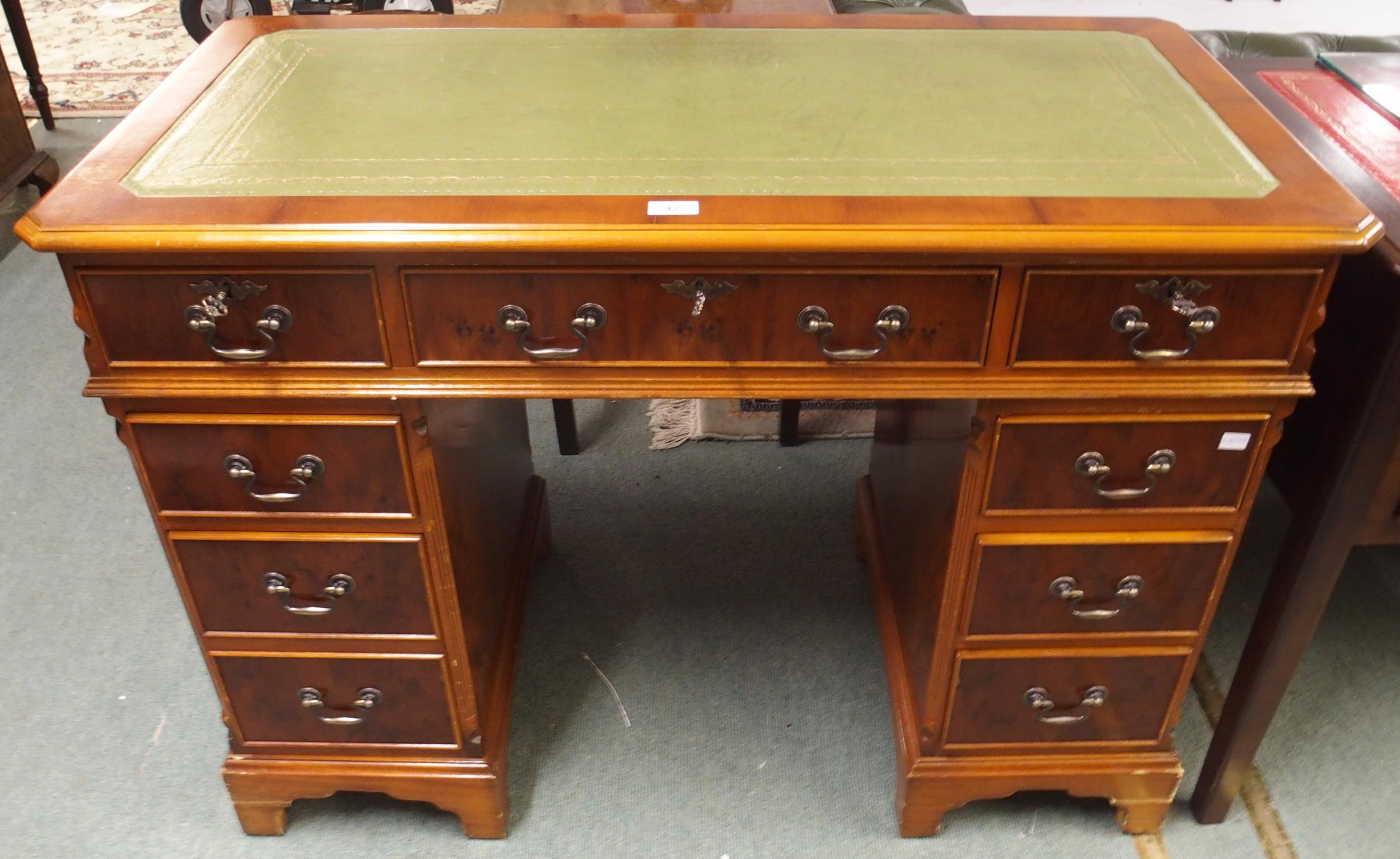 A 20th century mahogany twin pedestal writing desk with green writing skiver over central long