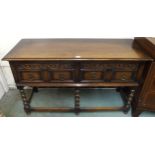 A 20th century oak baronial style two drawer buffet table on stretchered bobbin turned supports,
