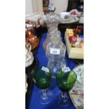 A silver mounted hour glass decanter, another hour glass decanter, a three ring decanter and a