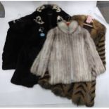 Two black rabbit fur jacket, a pale grey fur jacket, a patterned black and cream fur coat, and a