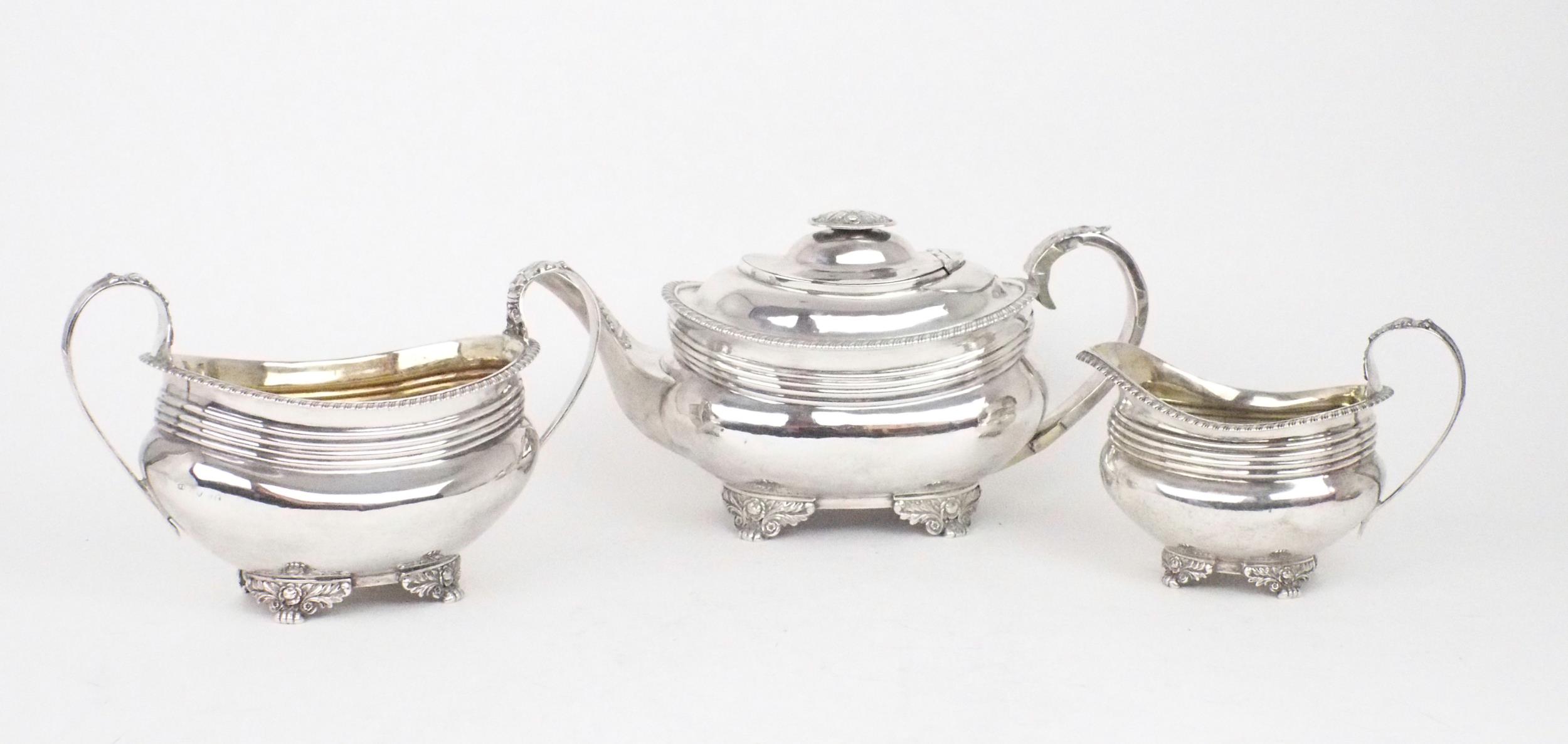 A MATCHED GEORGE III THREE PIECE SILVER TEA SERVICE of squat shaped rectangular form, the bodies