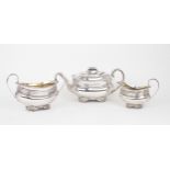 A MATCHED GEORGE III THREE PIECE SILVER TEA SERVICE of squat shaped rectangular form, the bodies