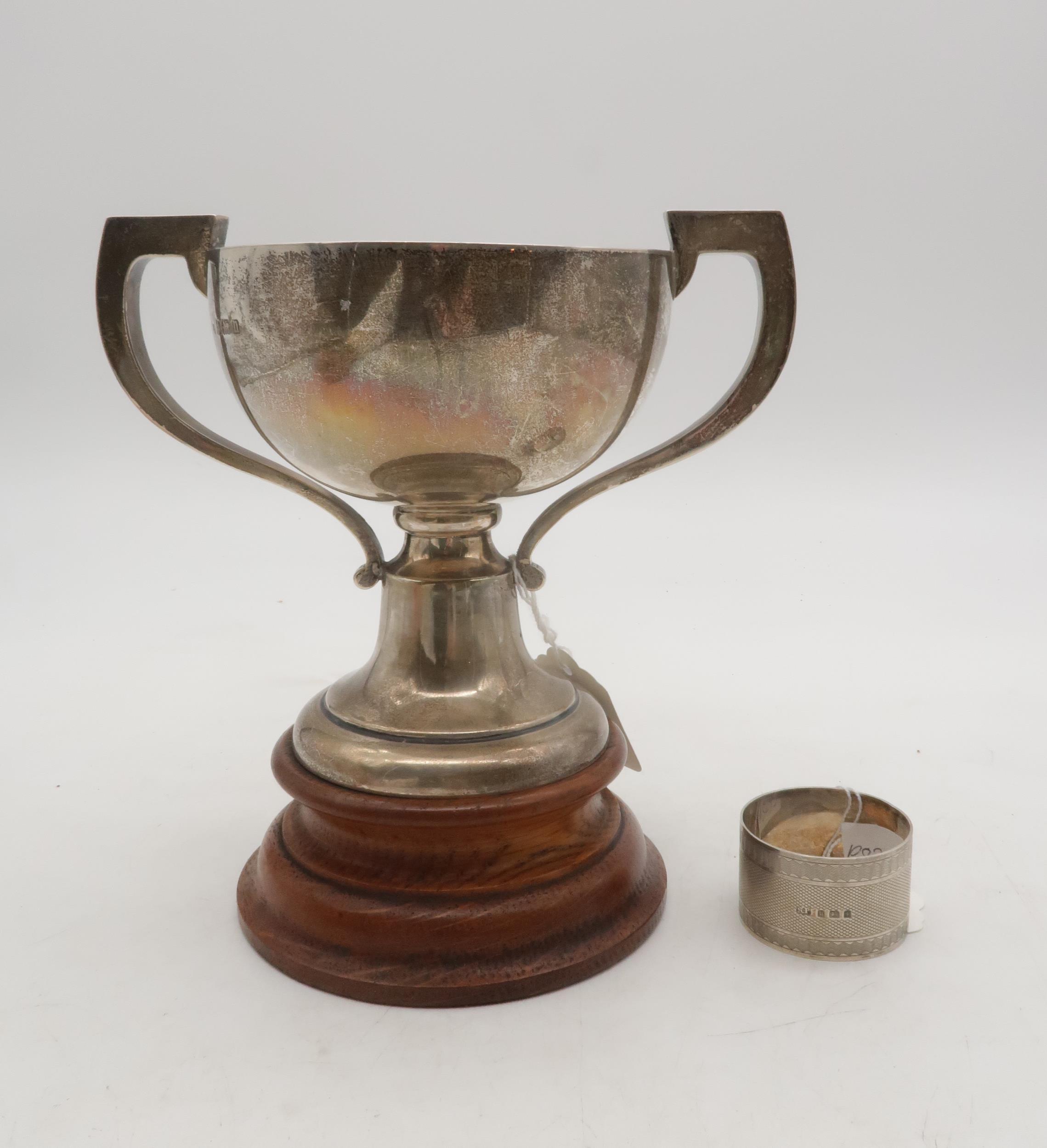 An Edwardian silver twin handled trophy cup, with a turned wooden base, by William Neale Ltd,