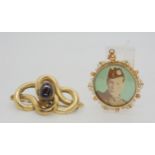 A 9ct gold double sided photo locket with a yellow metal knot brooch set with a garnet, weight