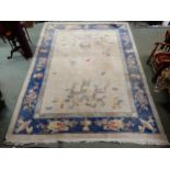 A cream ground Oriental style rug with dragon design on ground surrounded by blue floral borders,