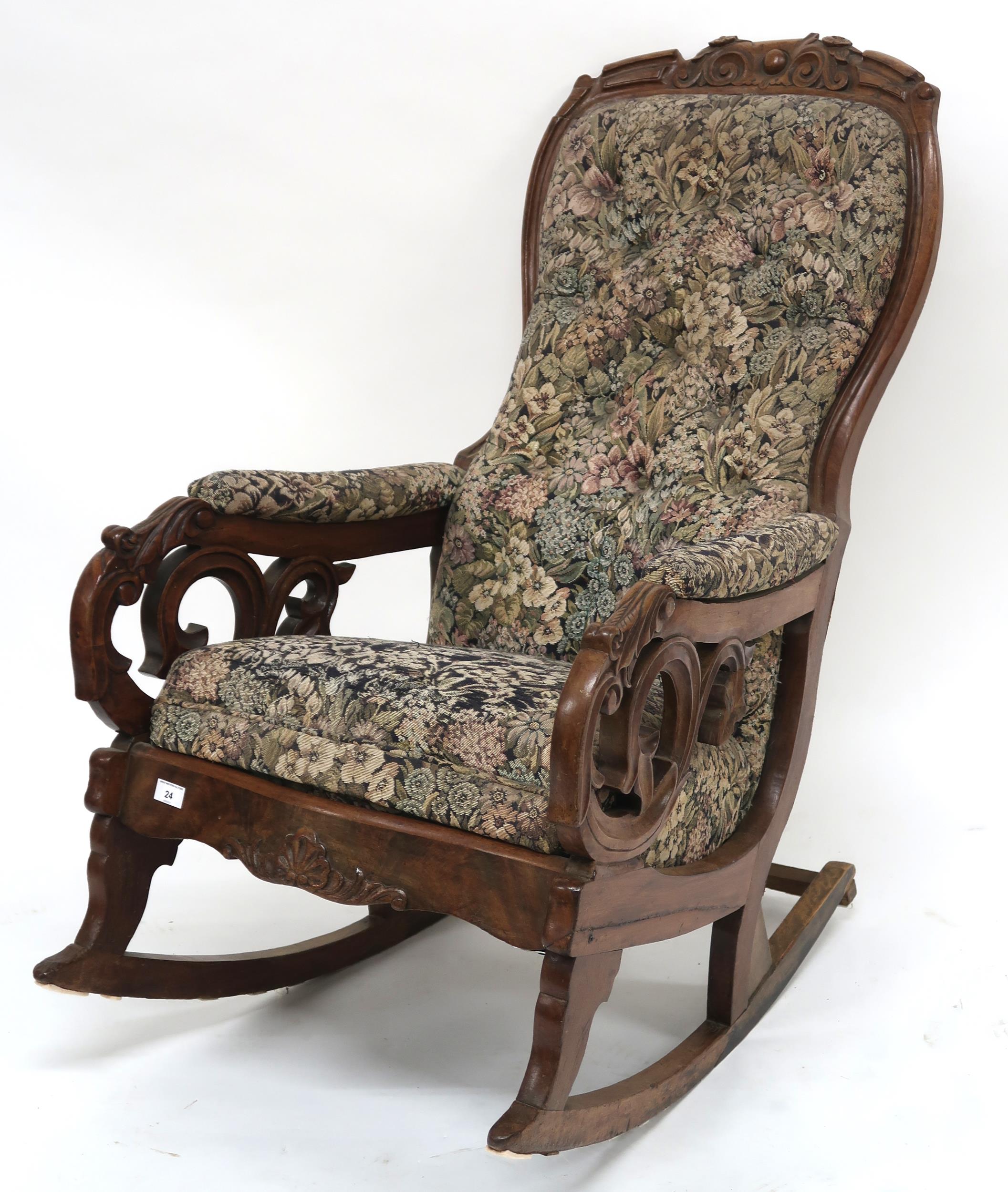 A Victorian walnut framed rocking chair with floral button back upholstery, carved scrolled arms