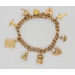 A 9ct gold charm bracelet with heart shaped clasp and hung with nine 9ct and yellow metal charms