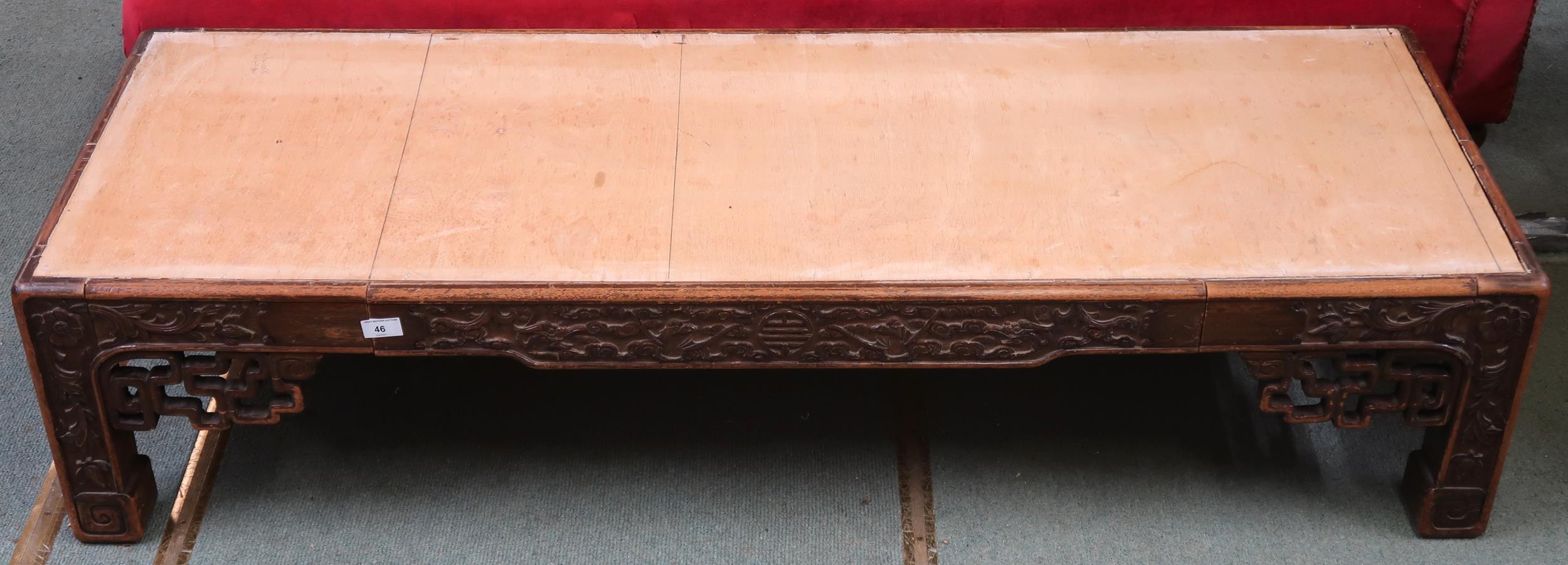 A 19th century Oriental hardwood low coffee table with extensively carved fretwork friezes on shaped