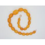 A string of amber coloured beads, largest bead 27mm x 19mm, weight approx 43.2gms Condition Report:
