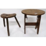 A 19th century elm three legged milking stool with kidney shaped seat with pierced handle and an oak