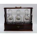 A Three cut glass decanter tantalus, with three silver spirit labels Condition Report:Available upon