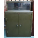 A mid 20th century Howden steel tool/stationary cabinet with pair of glazed sliding doors over