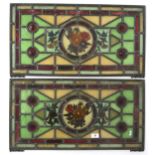 A pair of stained leaded glass panels with central floral painted pane flanked by blown rondels,