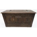A 20th century oak baronial style chest with extensively carved front and sides, 50cm high x 92cm