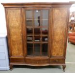 An early 20th century mahogany bookcase with central bowed glazed door flanked by walnut veneered