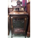 A Victorian mahogany music cabinet with bevelled mirror surmount over single glazed door on scrolled