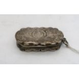 A Victorian silver vinaigrette, of shaped form, with engraved scrolling foliate decoration,