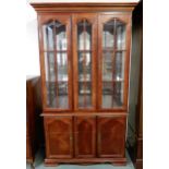 A 20th century mahogany glazed display cabinet with moulded cornice over pair of glazed doors over