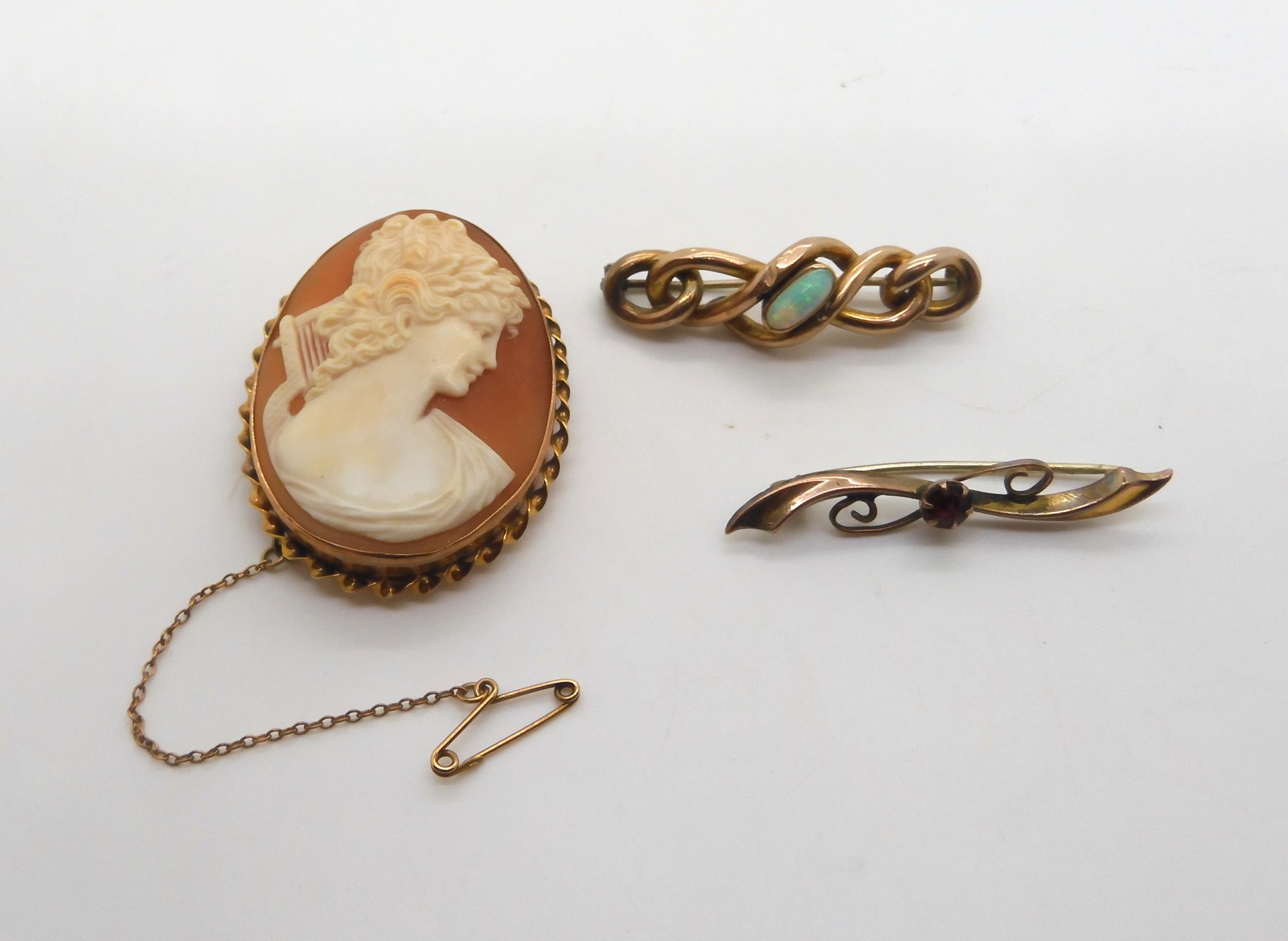 A 9ct gold mounted cameo brooch, a yellow metal opal brooch and a 9ct red gem brooch, weight