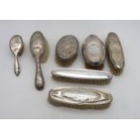 A collection of silver and white metal dressing table brushes, including an Art Nouveau example,