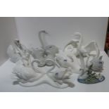 A collection of swan figures including two large Lladro examples, two smaller, a Coalport example,