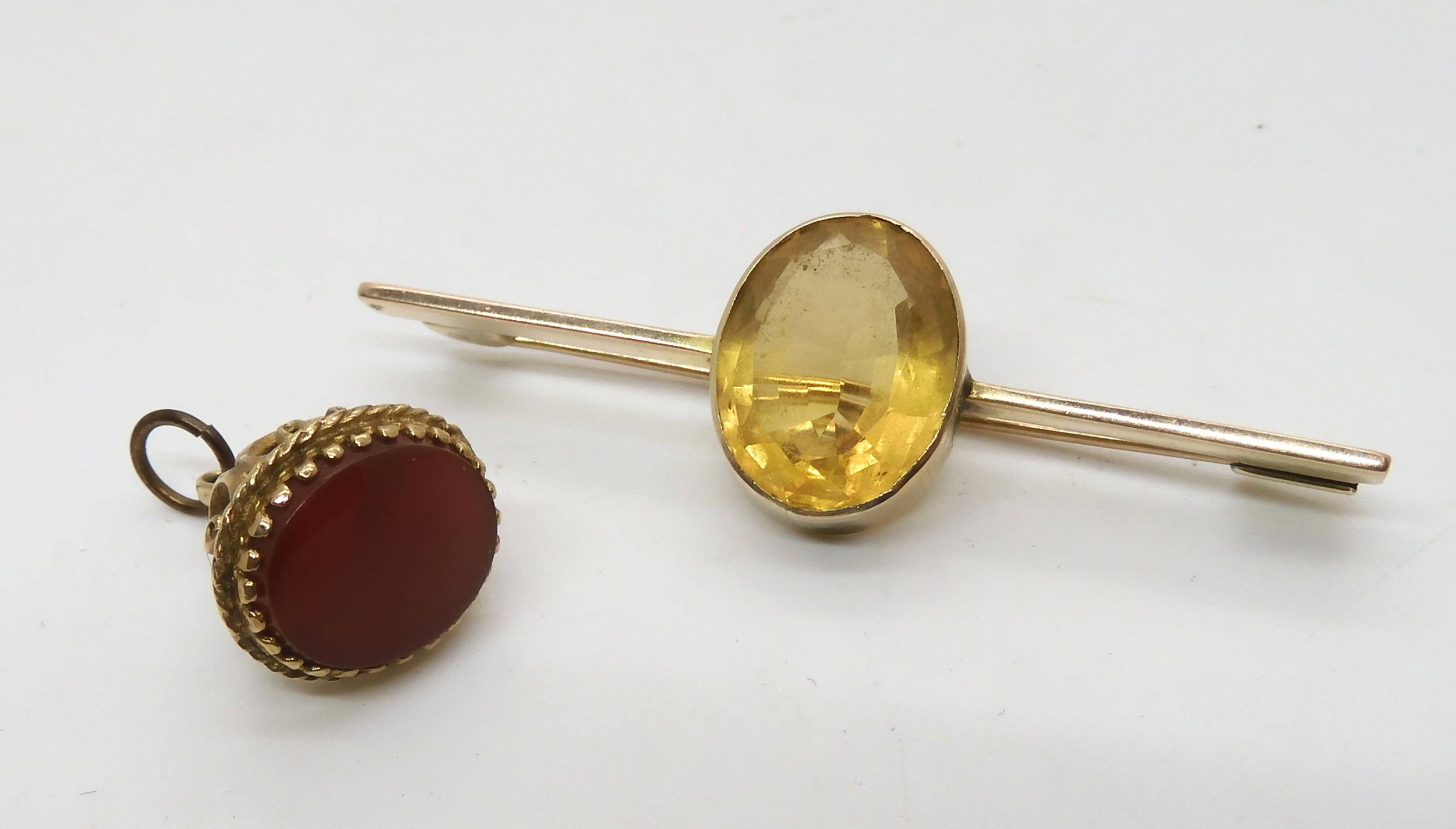 A 9ct gold fob seal and a yellow metal bar brooch set with a citrine, weight 9.5gms Condition