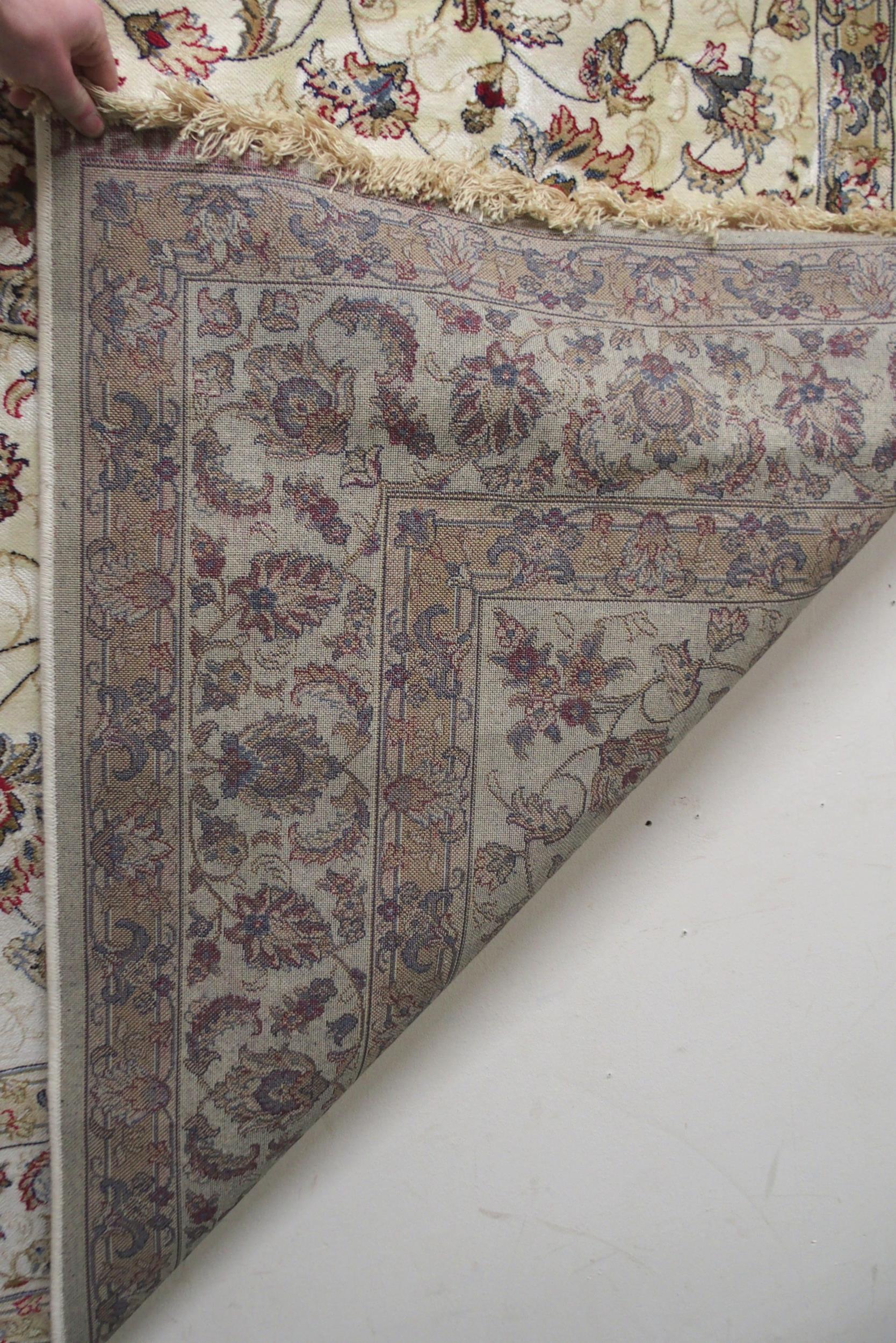 A cream ground machine made Kashmiri rug with all-over floral design and flower head borders, - Image 6 of 6