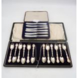 A cased set of silver tea spoons and sugar tongs,  with moulded scrollwork borders, by Gorham