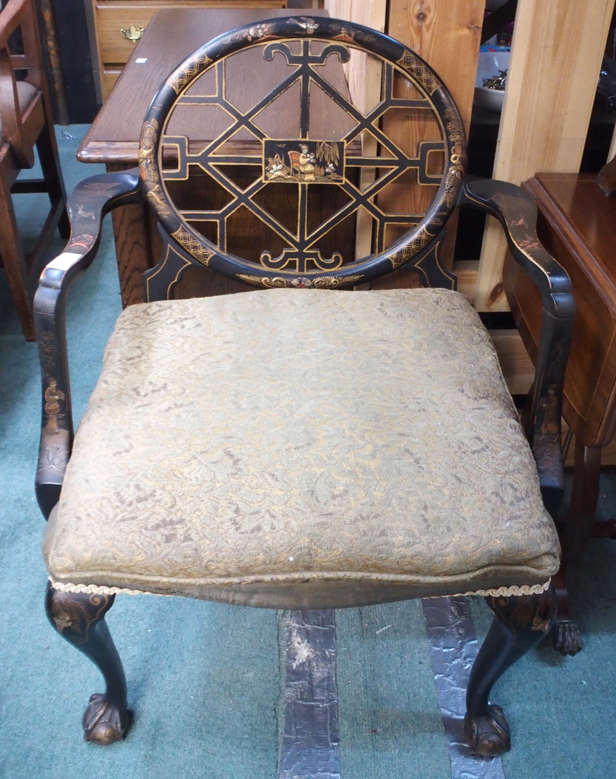 A 19th century Oriental ebonised open armchair with fret work splat on ball and claw supports,