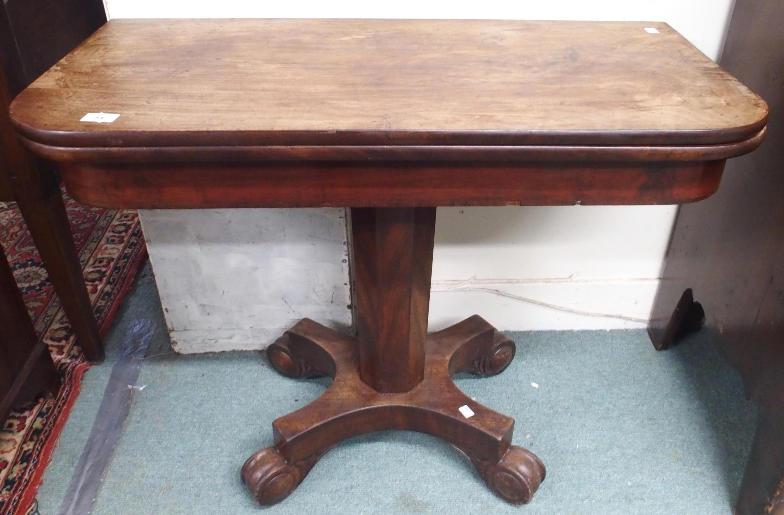 A Victorian mahogany fold-over tea table on octagonal pedestal terminating in scrolled quadrupedal