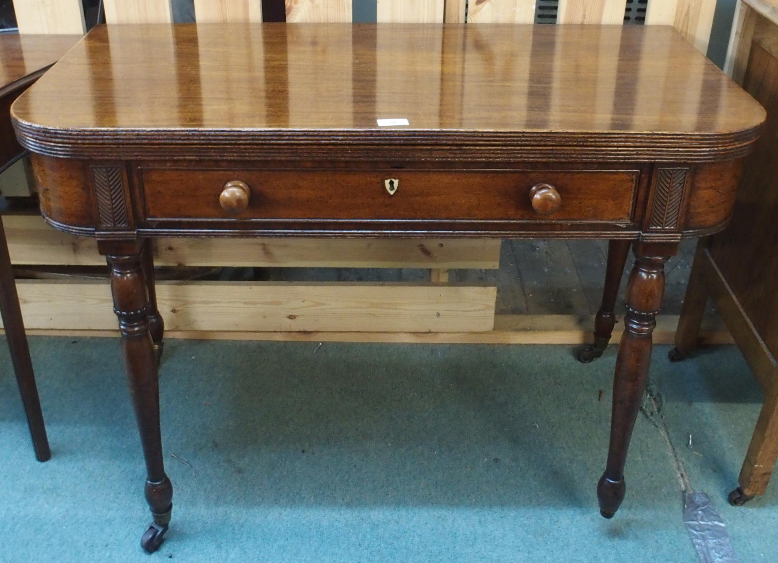 A Victorian mahogany single drawer fold-over tea table on turned supports terminating in casters (