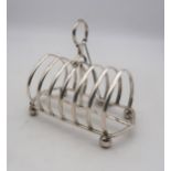 A Victorian silver six division toast rack, the ribs arched, with a loop carrying handle, on four