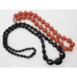 A string of coral beads, each bead approx 11.5mm, weight 32.5gms, together with a dark cherry