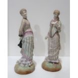 A pair of bisque figures of ladies in Victorian dress with diamond registration mark for 1879