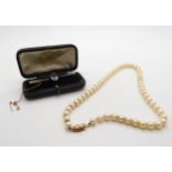 A string of cultured pearls with a 18ct gold pearl set clasp, and a 15ct gold aquamarine brooch,