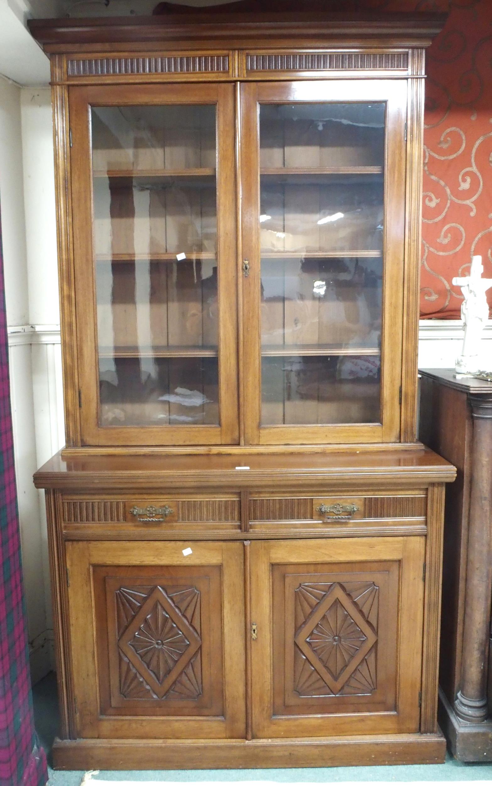 A Victorian mahogany bookcase on base with moulded cornice over pair of glazed doors over drawers