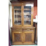 A Victorian mahogany bookcase on base with moulded cornice over pair of glazed doors over drawers